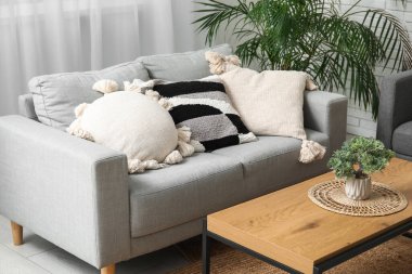 Oturma odasında şık yastıkları olan gri kanepe.