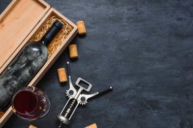 Şarap, cam, mantar ve siyah grunge arka planda açacağı olan bir kutu.