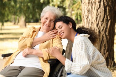 Genç Afro-Amerikalı kadın doktor ve tekerlekli sandalyede yaşlı bir kadın, yakın plan.
