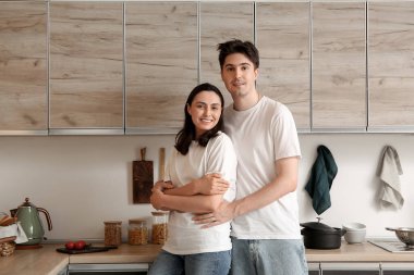 Mutfakta tezgahın yanında sarılan mutlu çift.