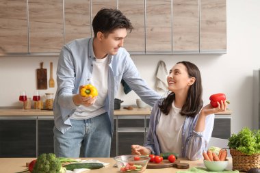 Mutlu genç çift mutfakta sebze salatası hazırlıyor.