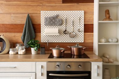 Mutfaktaki tahta duvarın yanında beyaz tezgah ve tahta tahta tahta var.