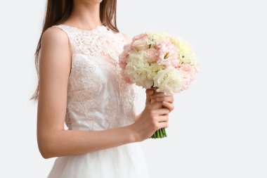 Beyaz arka planda güzel bir düğün buketi olan gelin