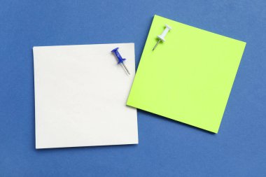 Mavi zemin üzerinde iğneler olan kağıt notlar