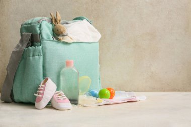 Gri arka planda çıngıraklı bebek çantası