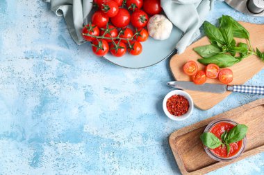 Fesleğenli domates sosu ve mavi arka planda sarımsak.