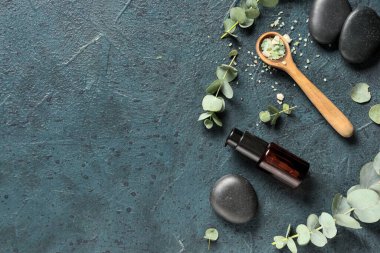 Spa taşları, deniz tuzu ve koyu mavi arka planda gerekli okaliptüs yağı.