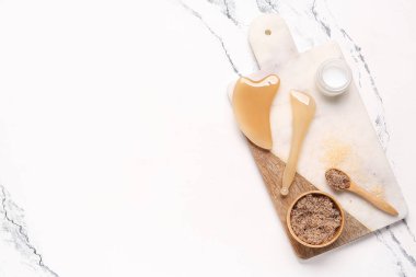 Tepsi, yüz masajı aletleri ve mermer arka planda deniz tuzu ile harika bir kompozisyon.