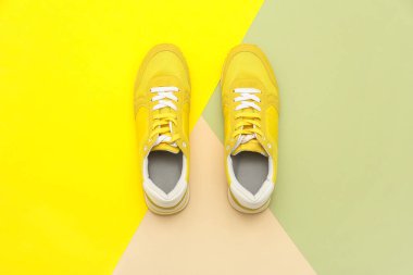 Renkli arka planda şık erkek sarı spor ayakkabıları.