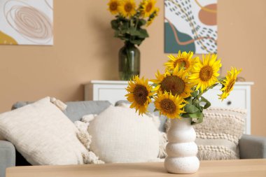 Şık oturma odasının içinde ayçiçekli vazolar.