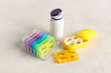 Plastik hap organizatörleri ve beyaz arka planda şişe.