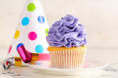 Parti şapkalı ve beyaz arka planda ıslık çalan tatlı bir kek.