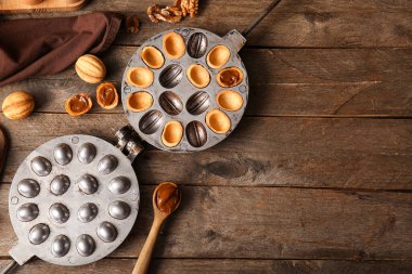 Ahşap arka planda lezzetli ceviz şekilli kurabiye pişirme biçimi