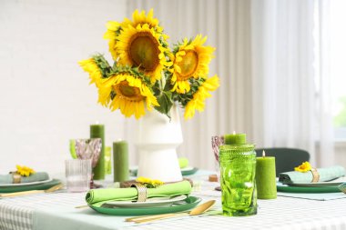 Oda da servis edilen yemek masasında bir buket ayçiçeği