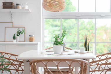 Yemek odasındaki pencere kenarındaki hasır sandalyeler ve masa