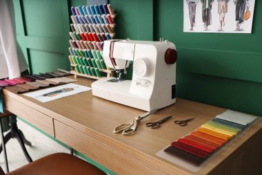 Atölyede dikiş makinesi, iplik makarası ve kumaş örnekleriyle terzinin işyeri