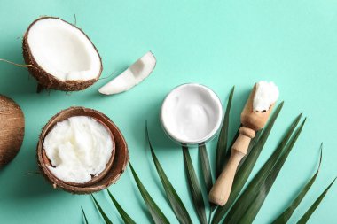 Ahşap kepçe ve turkuaz arka planda palmiye yaprağı ile hindistan cevizi kozmetik kremi kabuğu