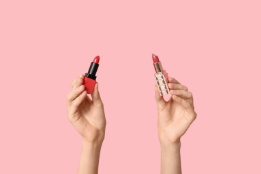 Pembe arka planda farklı ruj izleri olan kadın elleri.