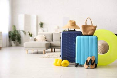 Plaj aksesuarlarıyla dolu bavullar ve oturma odasında şişme yüzük. Yaz tatili kavramı