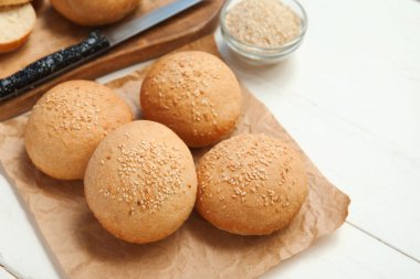 Beyaz ahşap arka planda susam tohumlu taze çörekler pişireceğim.