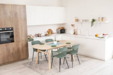Tezgahlı, raflı ve yemek masalı aydınlık mutfağın bulanık görüntüsü