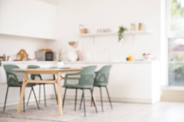 Tezgahlı, raflı ve yemek masalı aydınlık mutfağın bulanık görüntüsü