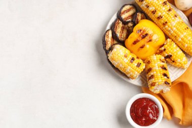 Izgara sebzeli tabak, beyaz arka planda soslu peçete ve kase.