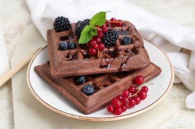 Beyaz arka planda taze böğürtlen ve nane şekerli Belçika Waffle tabağı.