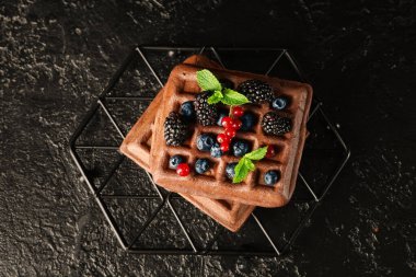 Taze böğürtlenli Belçika waffle 'ı ve siyah arkaplanda nane şekeri.