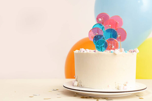 Торт с воздушными шарами на день рождения на столе у белой стены