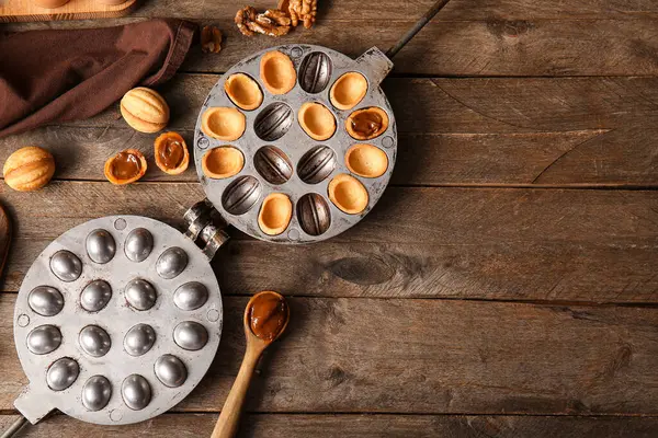 Ahşap arka planda lezzetli ceviz şekilli kurabiye pişirme biçimi