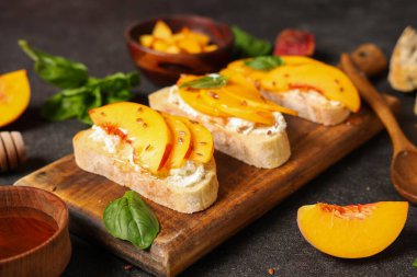 Siyah arka planda şeftali bruschetta, keten tohumu ve fesleğen, yakın plan.