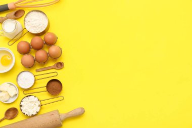 Sarı arka planda tatlı tarçınlı rulo hazırlamak için farklı malzemeler