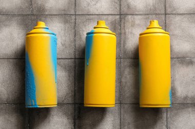 Gri karo arka planda sprey boya kutuları