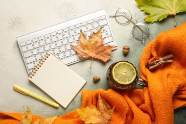 Klavyeli kompozisyon, boş defter, bir fincan çay ve grunge arkaplanda sonbahar yaprakları