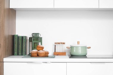 Kitaplı kekler ve mutfak tezgahında pişirme kabı.