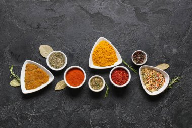 Farklı aromatik baharatlar ve koyu arkaplanda bitkiler içeren kompozisyon