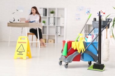 Ofiste çalışan iş kadını. Kapıcının tramvayı, süpürgesi ve ikaz levhası.