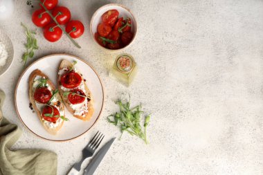 Lezzetli domates bruschetta tabağı ricotta ve beyaz arka planda mikro yeşiller.