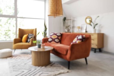 Bulanık oturma odası, kırmızı kanepe, koltuk ve masa.