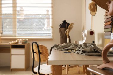 Terzi çalışma alanı, manken ve ruh hali kurulu olan şık bir atölye.