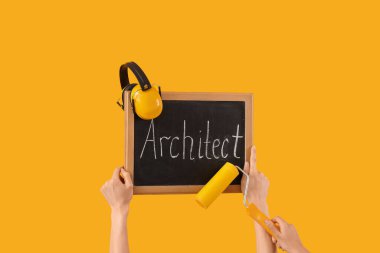 ARCHITECT sözcüğüyle yazı tahtası tutan kadınlar ve sarı arka planda malzemeler