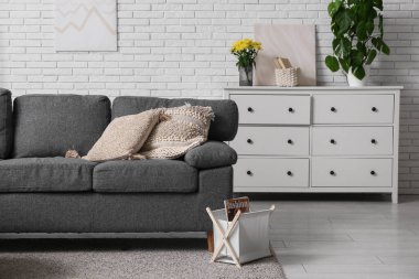 Oturma odasının içinde yastıklı ve kitap tutacağı olan rahat bir kanepe.