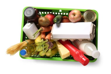 Farklı taze ürünlerle dolu yeşil alışveriş sepeti ve beyaz arka planda yumurta tepsisi. Üst görünüm