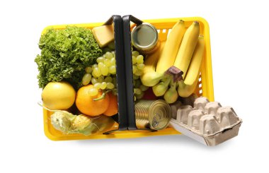 Farklı taze ürünlerle dolu sarı alışveriş sepeti ve beyaz arka planda yumurta tepsisi. Üst görünüm