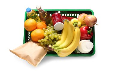 Farklı taze ürünlerle dolu yeşil alışveriş sepeti ve beyaz arka planda muzlar. Üst görünüm