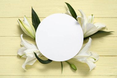 Beyaz zambak çiçekli kompozisyon ve pembe ahşap arka planda boş yuvarlak kart. Üst görünüm