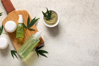 Beyaz arka planda yaprakları olan kenevir kozmetik ürünleri şişeleri ve kavanozları