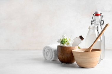 Pirinç suyu şişeleri, temiz havlu ve açık arkaplanda çiçekler.