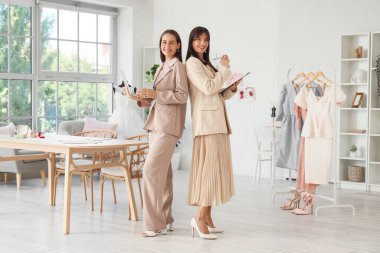 Ofisinde dizüstü bilgisayarı ve panosu olan kadın düğün organizatörleri.